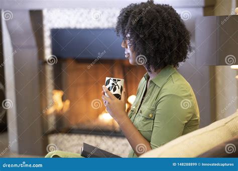 Black Female Drinking A Cup Of Coffee Or Cbd Tea In A Living Room Stock