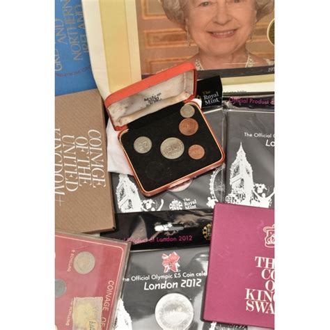 A CARDBOARD BOX CONTAINING CASED COINS AND YEAR COIN SETS To Include