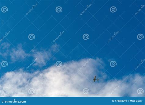 Small Commercial Airplane Flying High In A Cloudy Sky Stock Image