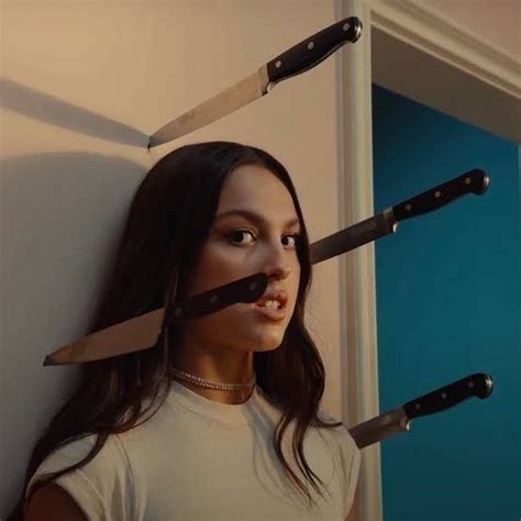 A Woman Holding Two Knives In Front Of Her Face