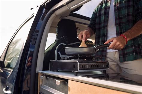 Premium Photo Unrecognizable Young Man Cooking In His Camper Van