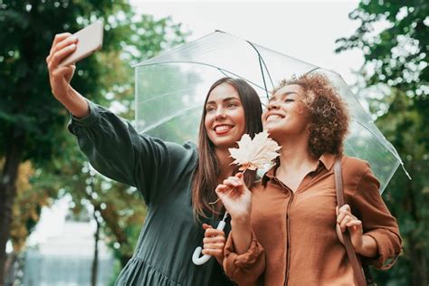 Meilleurs Amis Prenant Un Selfie Sous Leur Parapluie Photo Gratuite