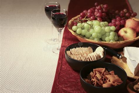 Two Glasses Of Wine With Cheese And Crackers With Some Red And Green