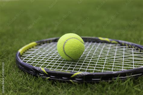 Tennis ball and racket on green grass background Stock Photo | Adobe Stock