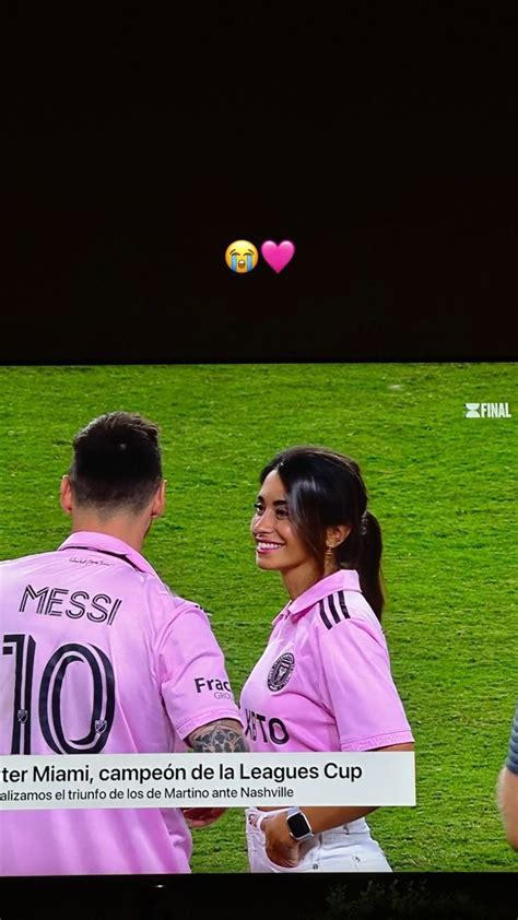 Two Soccer Players Are Talking To Each Other In Front Of A Tv Screen