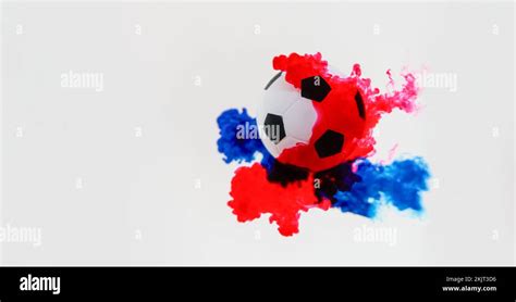 Soccer ball with red and blue color splash on white background. Concept ...