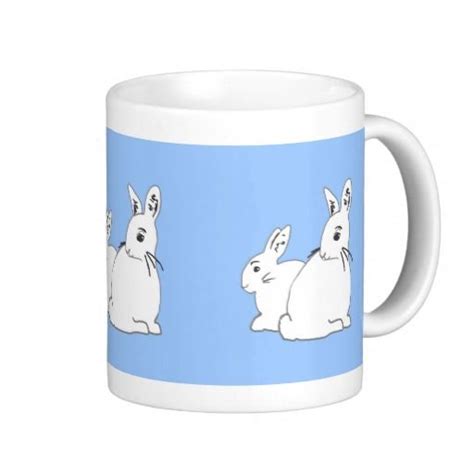 Two White Rabbits Sitting On Top Of A Blue Background Coffee Mug With The Same Design