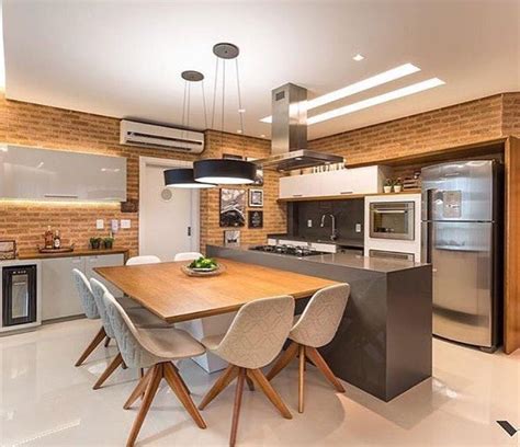 An Open Kitchen And Dining Room Area With Brick Walls White Flooring