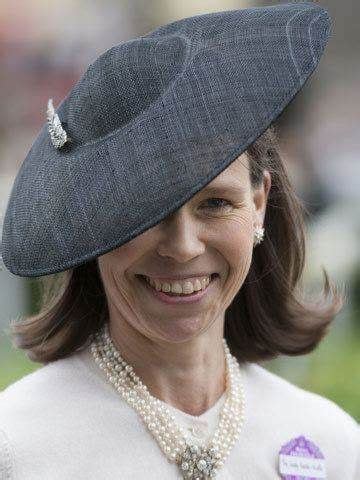 A Woman Wearing A Gray Hat And Pearls