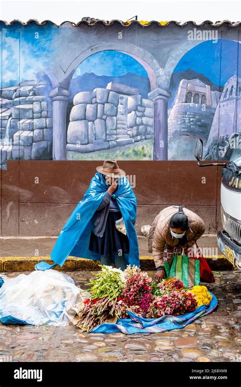 An Indigenous Woman Selling Fresh Flowers In The Rain At A Street