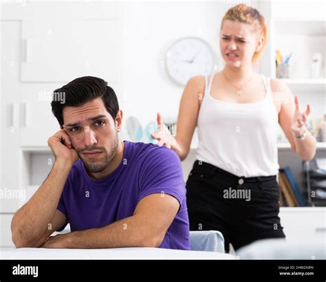 Stressed Man At Table With Screaming Wife Behind Stock Photo Alamy