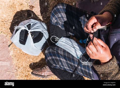 hands of an Andean woman spinning brown alpaca fiber in an ancestral ...