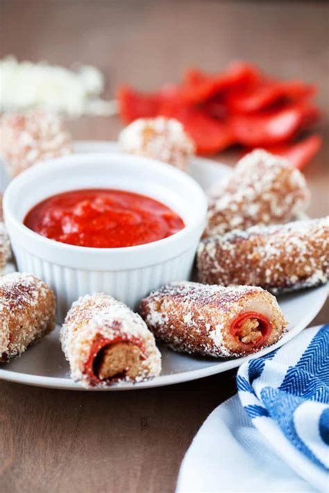 several pastries on a plate with dipping sauce