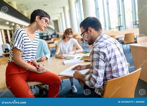 Happy Group Of Students Studying And Working Together In A College