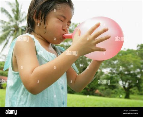 Close-up of a girl blowing a balloon Stock Photo - Alamy