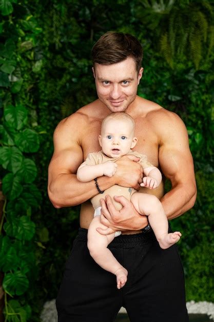 Premium Photo Man Holding Baby In Arms A Man Holding A Baby Tenderly