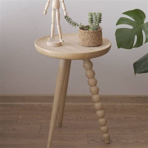 A Small Wooden Table With A Potted Plant On It And A White Skeleton