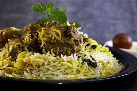 Le Poulet Biryani Sur Le Noir Plat Avec Le Rayetha Et La Sauce Au Jus