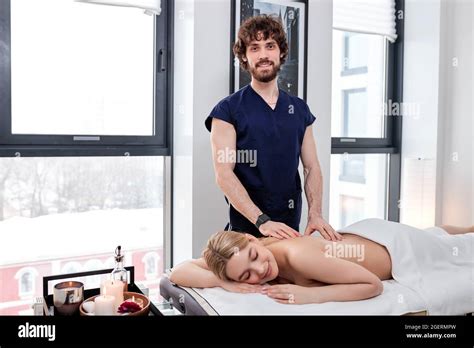 Portrait Of Bearded Nice Masseur In Uniform Carefully Doing Massage On