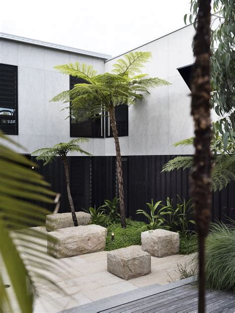 An Outdoor Courtyard With Palm Trees And Stone Benches