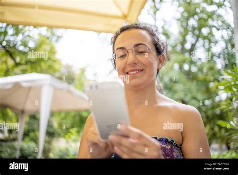 Pretty Spanish Woman With Mobile Phone Smiling Stock Photo Alamy