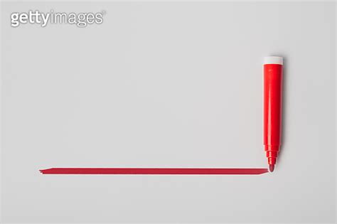 Red Highlighter Pen And A Hand Drawn Red Line Isolated On Gray