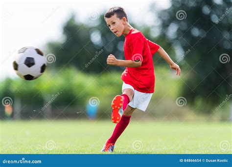 Muchacho Que Golpea El Balón De Fútbol Con El Pie Foto de archivo