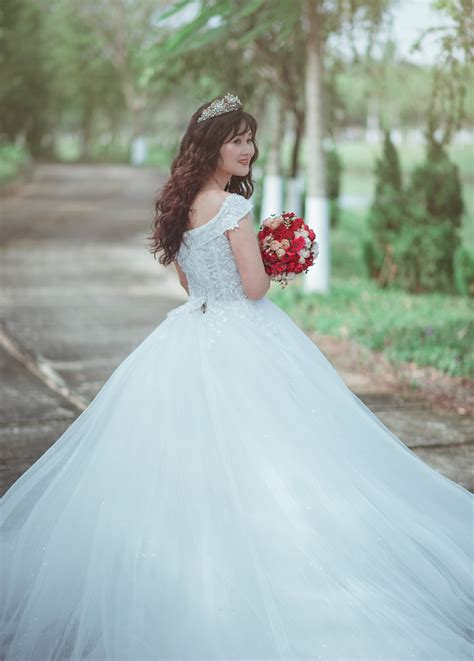 Free photo: Woman in White Wedding Dress Holding Red Bouquet