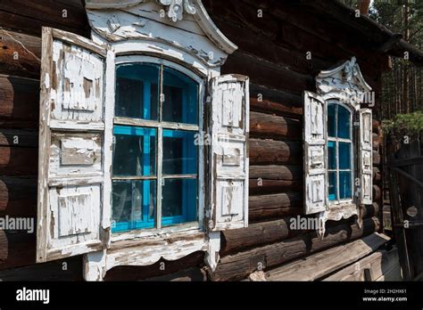 Traditional Wooden House With White Windows And Shutters In The Open