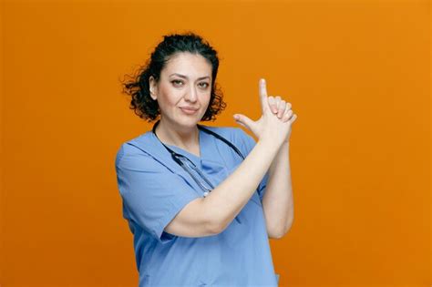 Confiada Doctora De Mediana Edad Con Uniforme Y Estetoscopio Alrededor