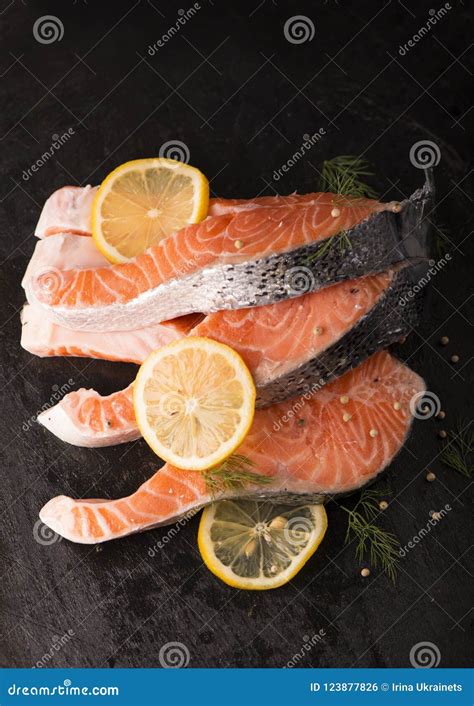 Filetto Di Pesce Di Color Salmone Crudo Su Fondo Nero Fotografia Stock