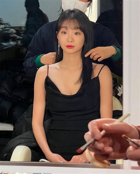 A Woman Is Getting Her Hair Done In Front Of A Mirror While Another