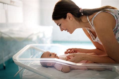 Mother Holding Her Newborn Baby Child After Labor In A Hospital Stock