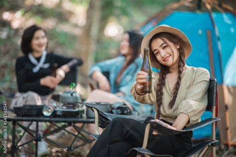 Young women cheer and drink beverage front of camping tent Stock Photo ...