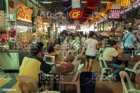 A Hawker Center Crowded With People Eating Food In Penang Stock Photo