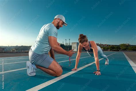 Instructor and athlete runner on the track. The athletics marks the ...