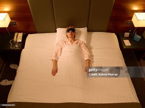 Woman Sleeping In Middle Of Double Bed Wearing Sleeping Mask High Res