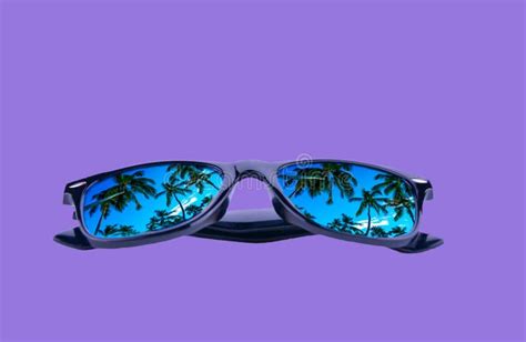 Sunglasses In A Black Frame With Palm Trees In The Reflection Of The Lenses On A Violet