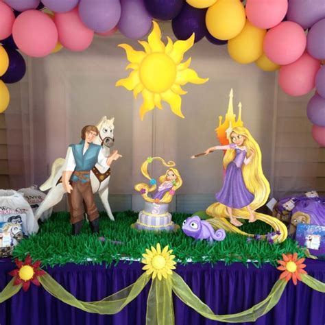 The Birthday Cake Is Decorated With Princess And Prince Figurines Balloons And Streamers