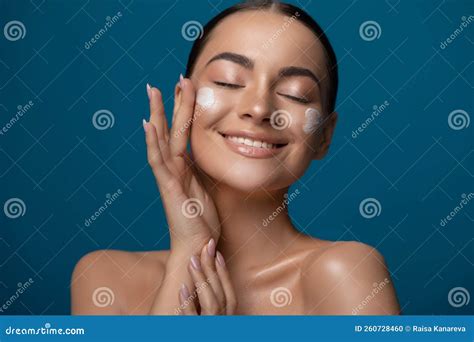 Close Up Beauty Portrait Of A Beautiful Young Woman Applying Face Cream