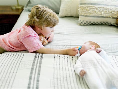 Boy Holding His Baby Brothers Pacifier Stock Photo Dissolve