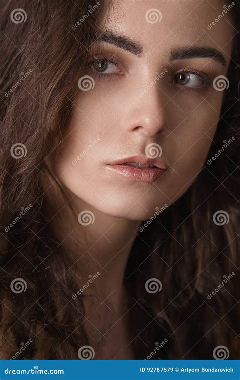 Dramatic Portrait Of A Young Beautiful Brunette Girl With Long Curly