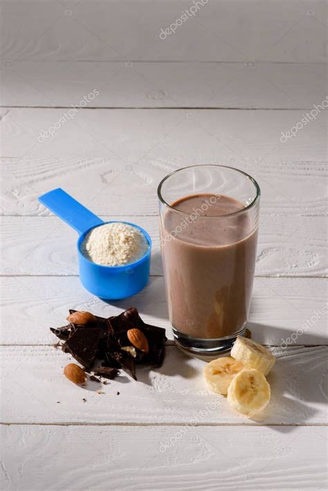 vaso de batido de proteínas con almendra plátano y chocolate sobre