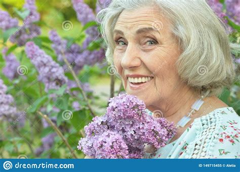 Portrait of Happy Senior Beautiful Woman with Lilacs Posing in Spring ...