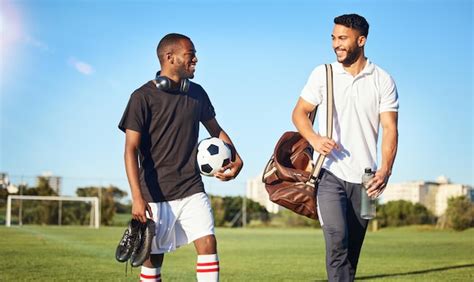 Entrenamiento de fútbol y amigos caminando en el campo después de un