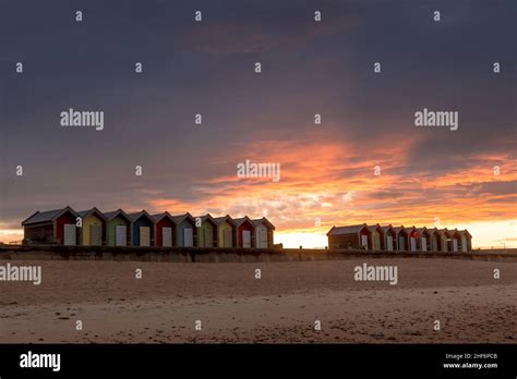 The vibrant and colorful beach huts by the promenade overlooking Blyth beach with a lovely ...