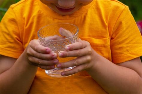 El Ni O Bebe Agua De Un Vaso Enfoque Selectivo Foto Premium