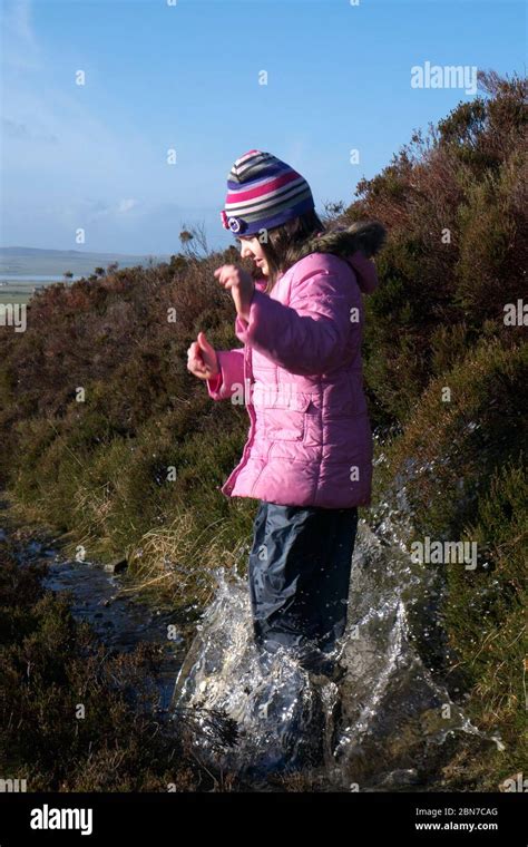 Young Girl Splashing In A Puddle Stock Photo Alamy