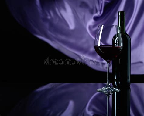 Wineglass And Bottle Of Red Wine On A Black Reflective Background Stock