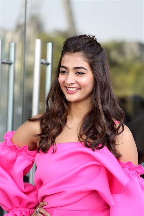 A Woman In A Pink Dress Smiling At The Camera